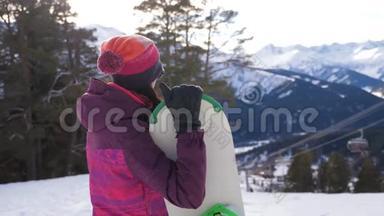 滑雪场山顶带<strong>滑雪板</strong>的女孩<strong>滑雪板</strong>。冬季运动与寒假概念。晴朗的冬天